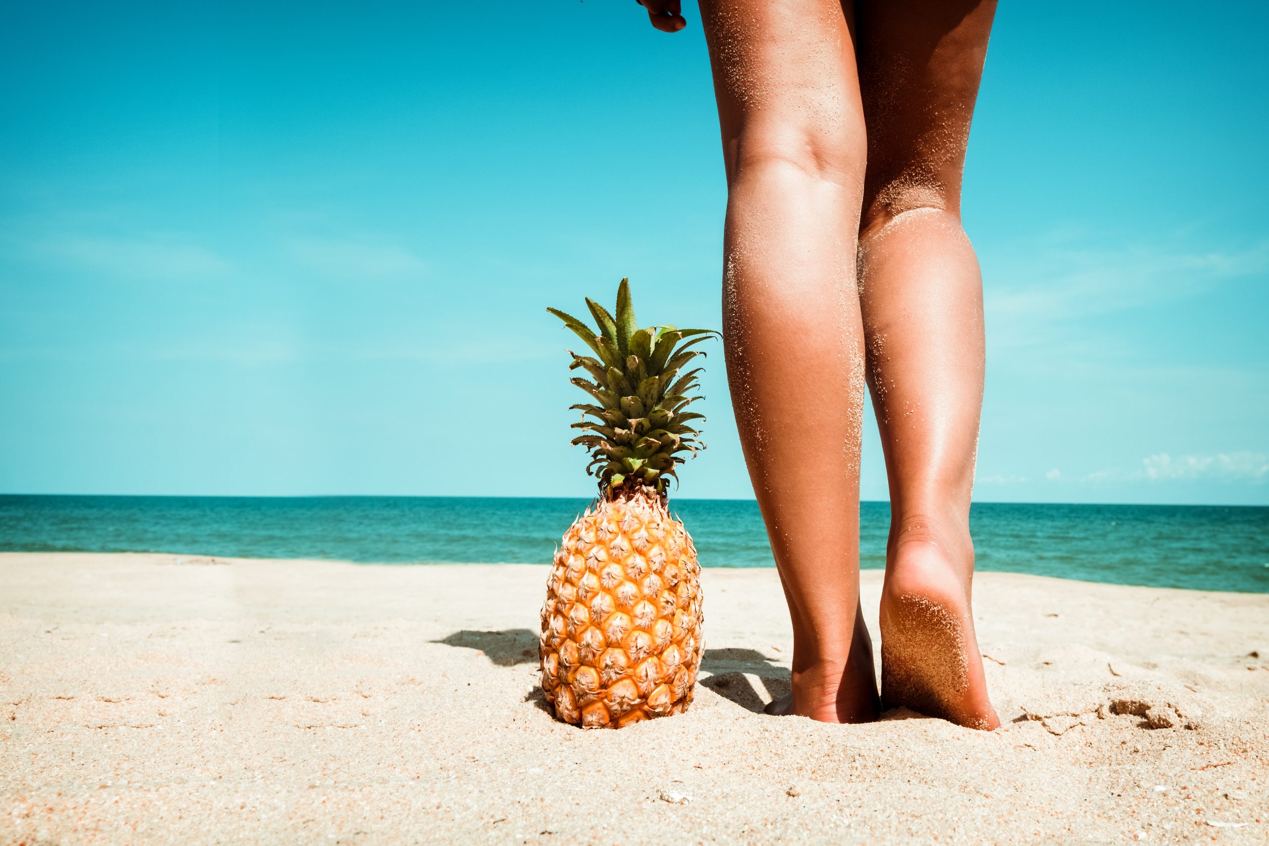 young woman standing with pineapple at tropical beach 13